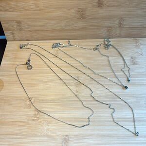 Bundle of 4 dainty silver tone necklaces. Great for layering.